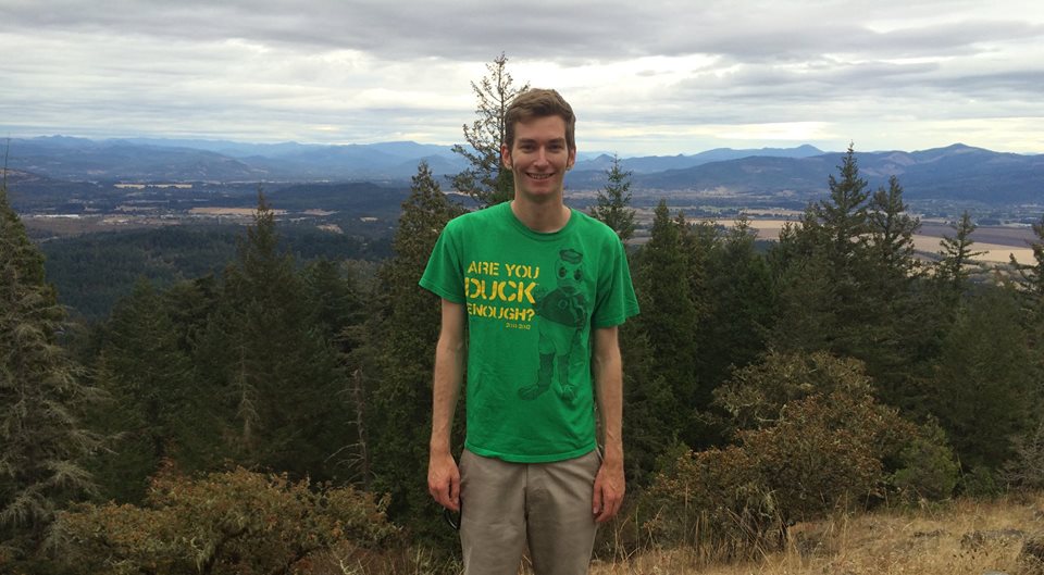 Elliott Killian ElliottKillian in Eugene Oregon with Forests behind him after a hike. He is wearing a University of Oregon Shirt on that says"Are you duck enough" And has a U of O Duck on it. Trying new places