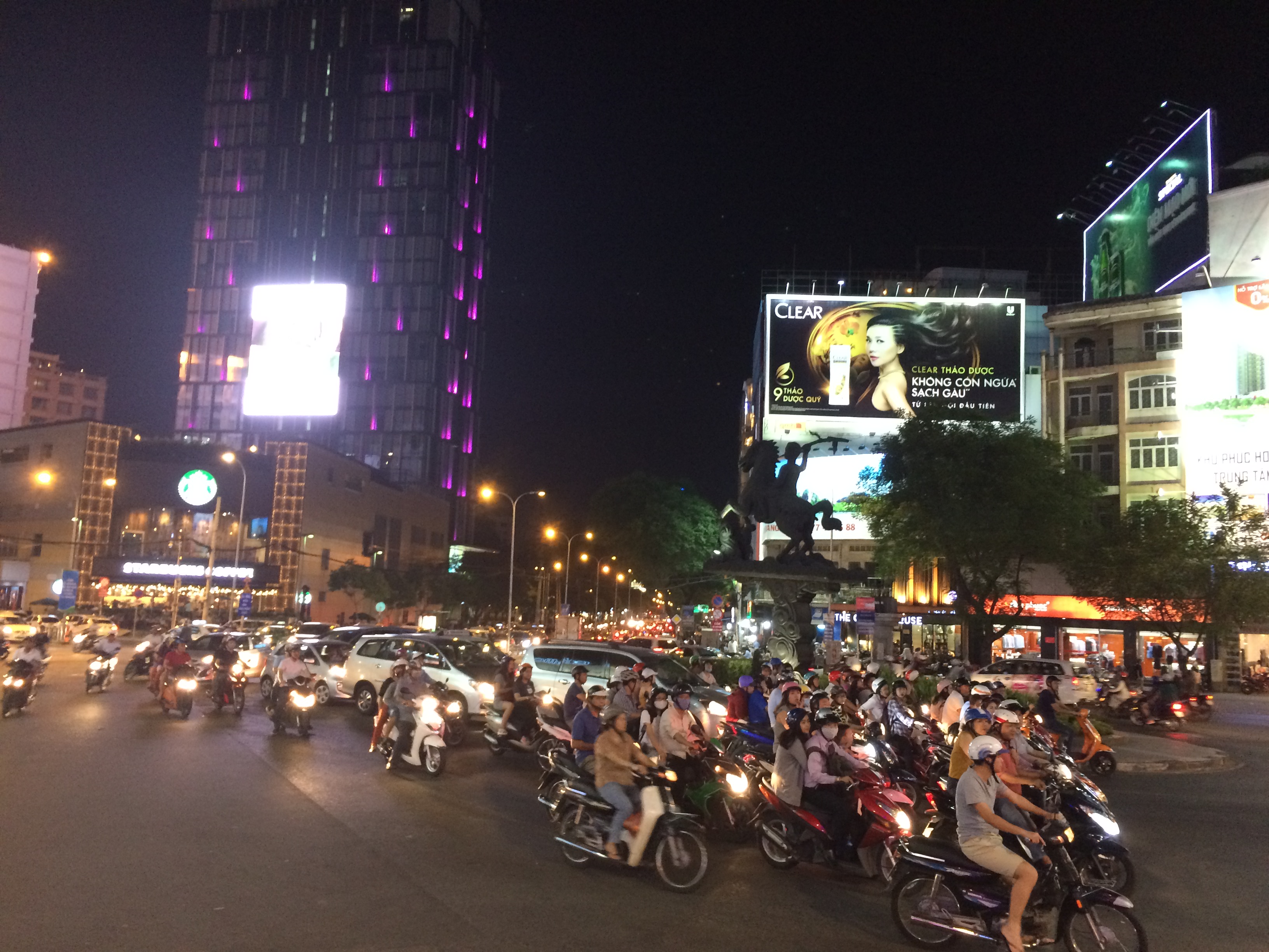 Ho Chi Minh city at night. The street is filled with motorbikes. 
