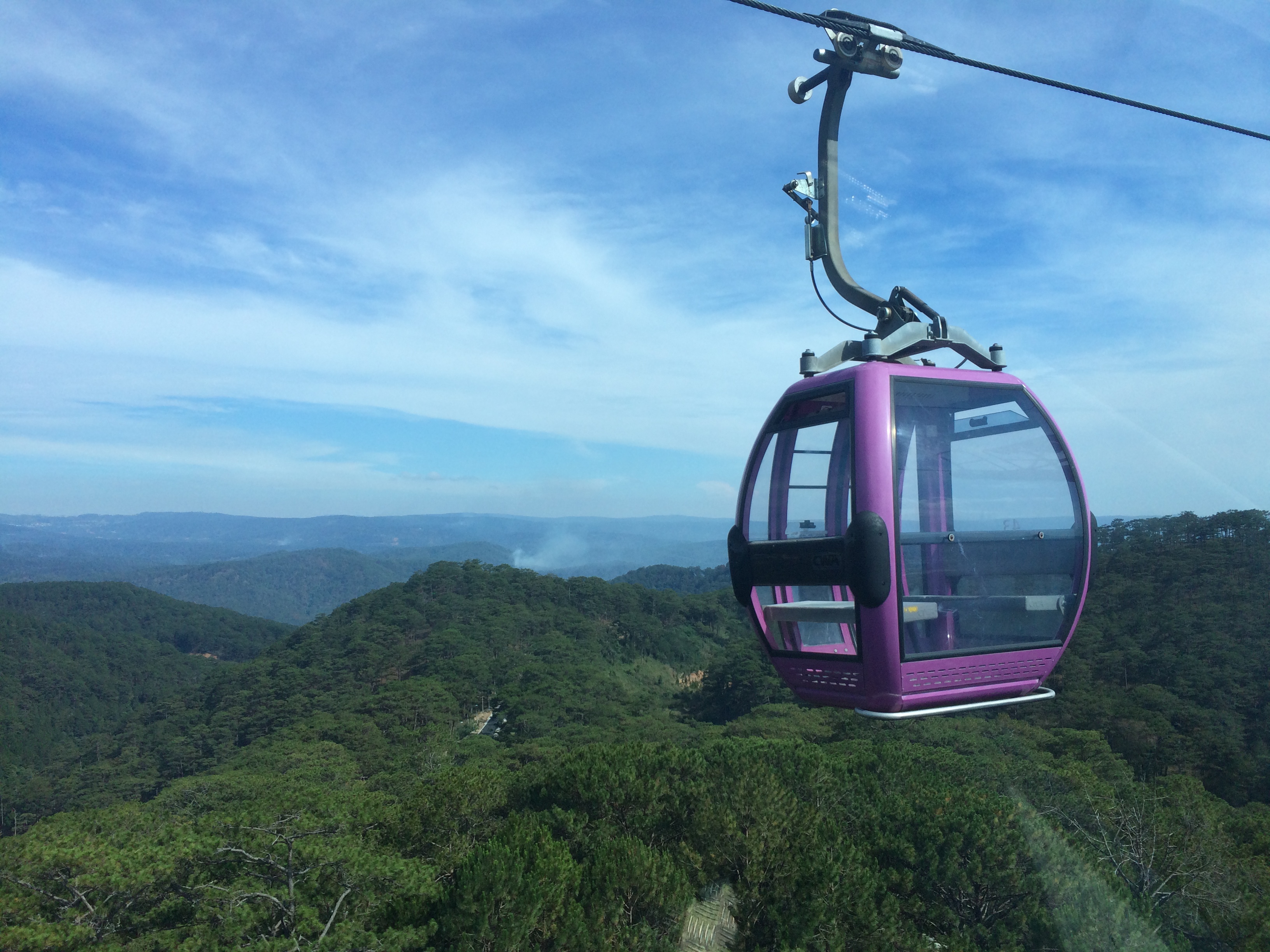 Cable car in Dalat Vietnam that takes you to a temple. There is forests all around as you ride in the car. 