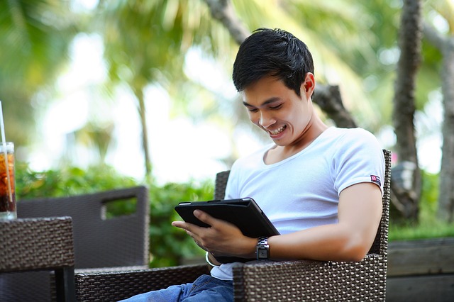 Man using a tablet computer. Why tech workers should learn Indonesian. 